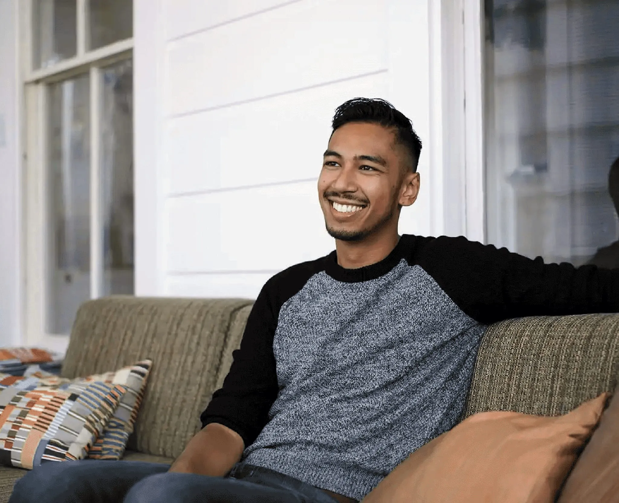 Shaun sitting on a sofa and smiling